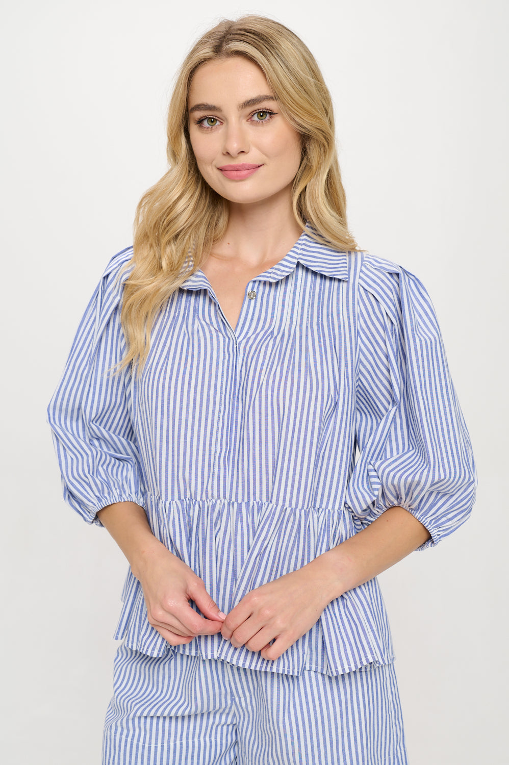 Model wearing a blue and white striped peplum top with a collar and 3/4 sleeves.