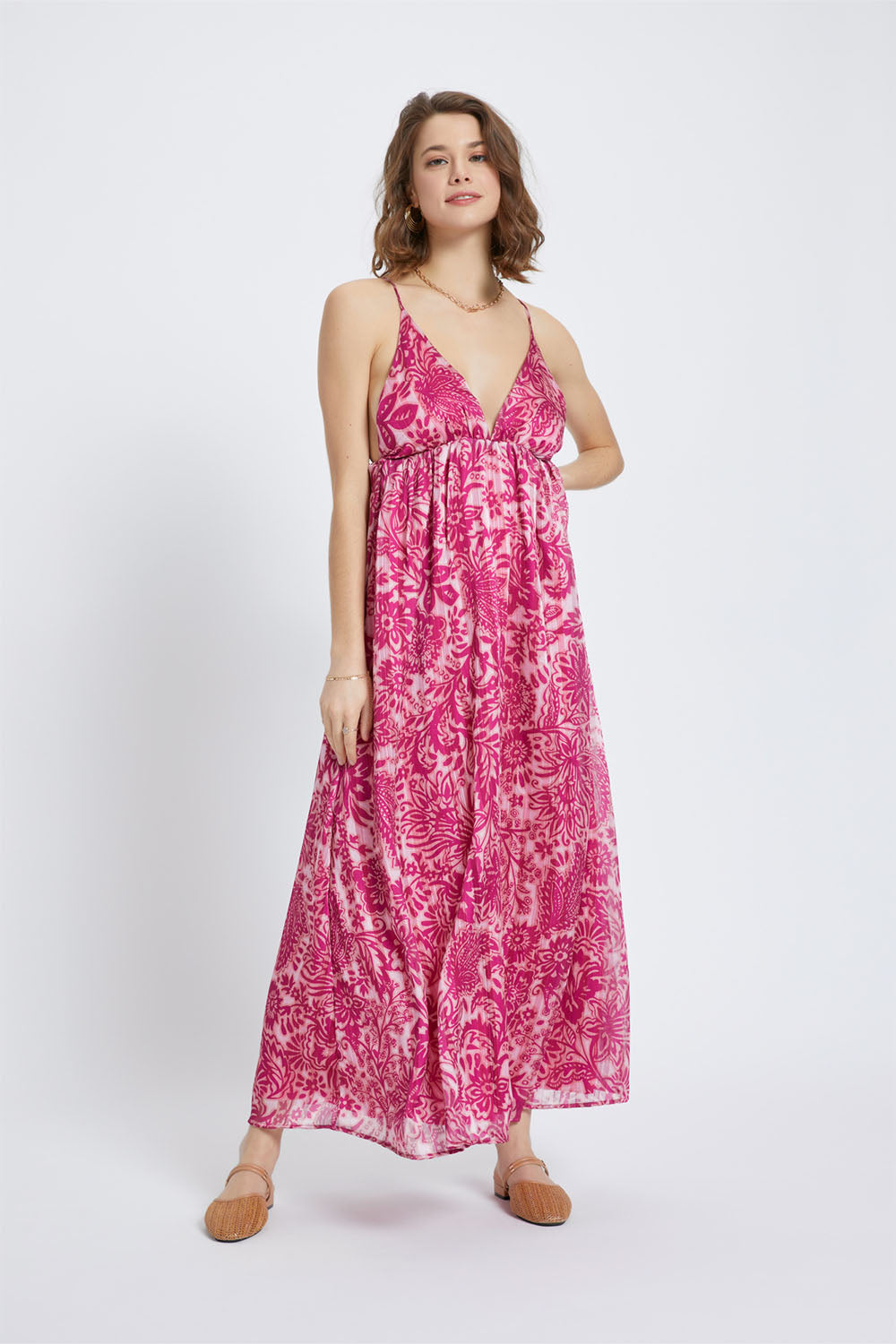 Model wearing the Magenta Gold Azure Maxi Dress with deep V-neckline and vibrant pink floral print on a flowing silhouette.