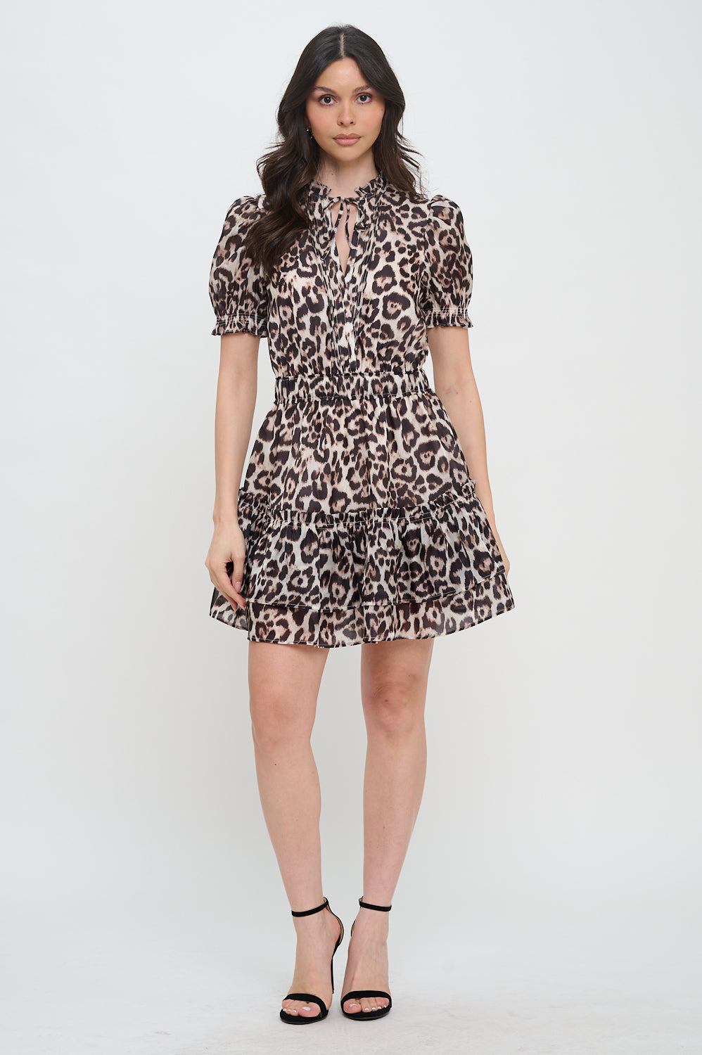 Model wearing the Gold Feline Puff Sleeve Short Dress from Meet Me in Santorini, a leopard print mini dress with a tie-neck and tiered skirt.