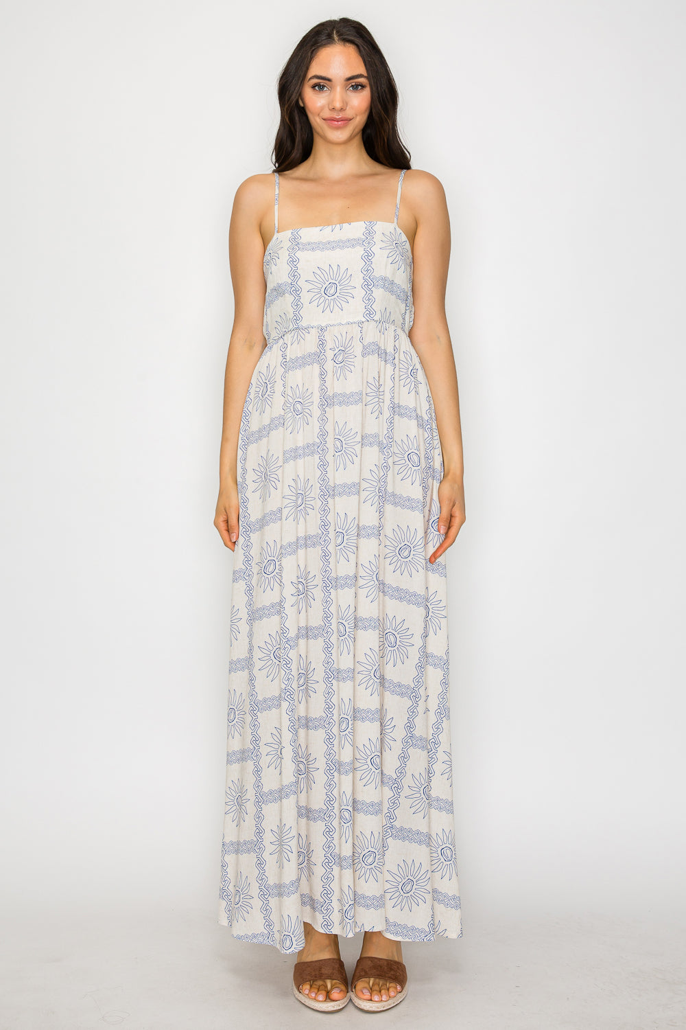 Woman wearing a smocked blue print maxi dress with spaghetti straps – relaxed feminine resortwear inspired by Mediterranean landscapes