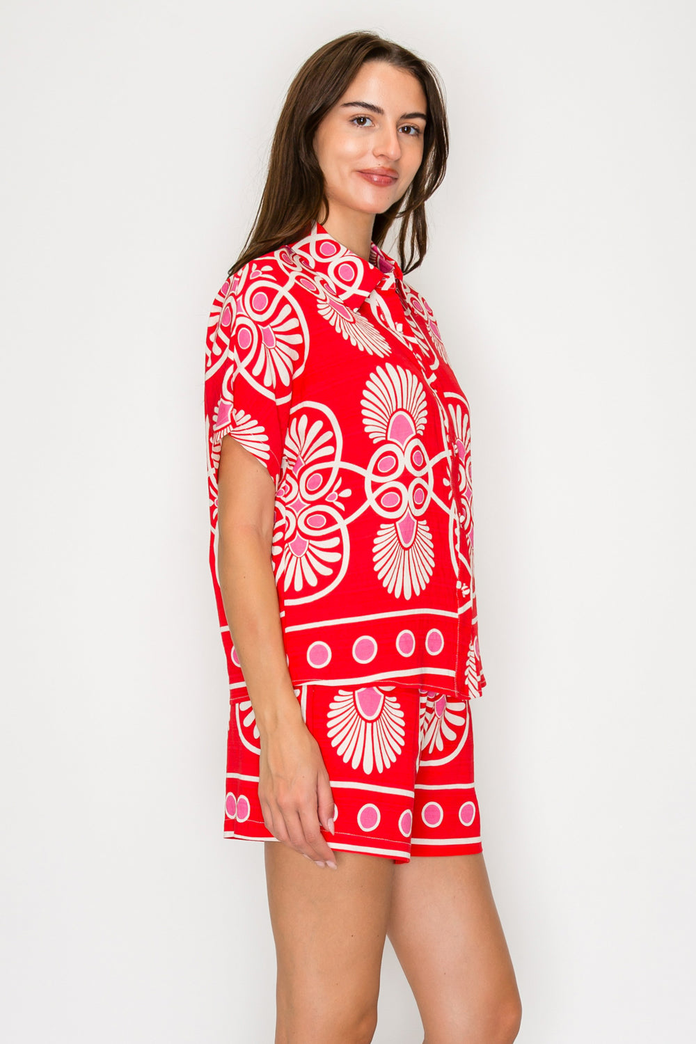 Woman wearing a red dress with white floral patterns on a white background