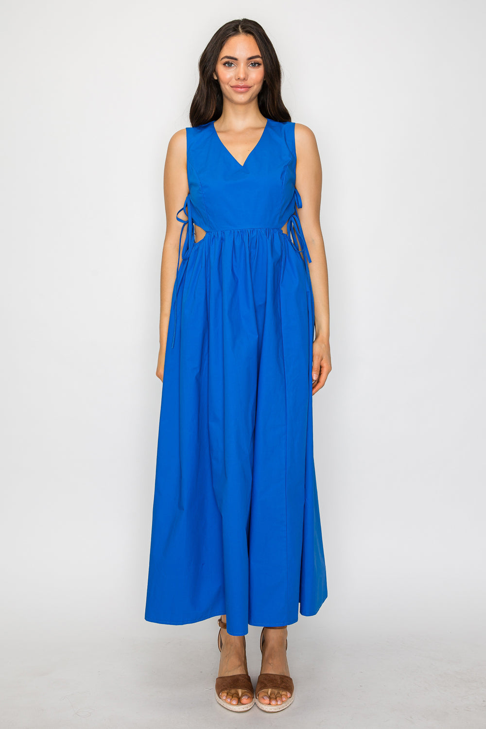 Model wearing a sleeveless Aegean blue maxi dress with a V-neckline, side-tie waist, and flowy A-line silhouette.