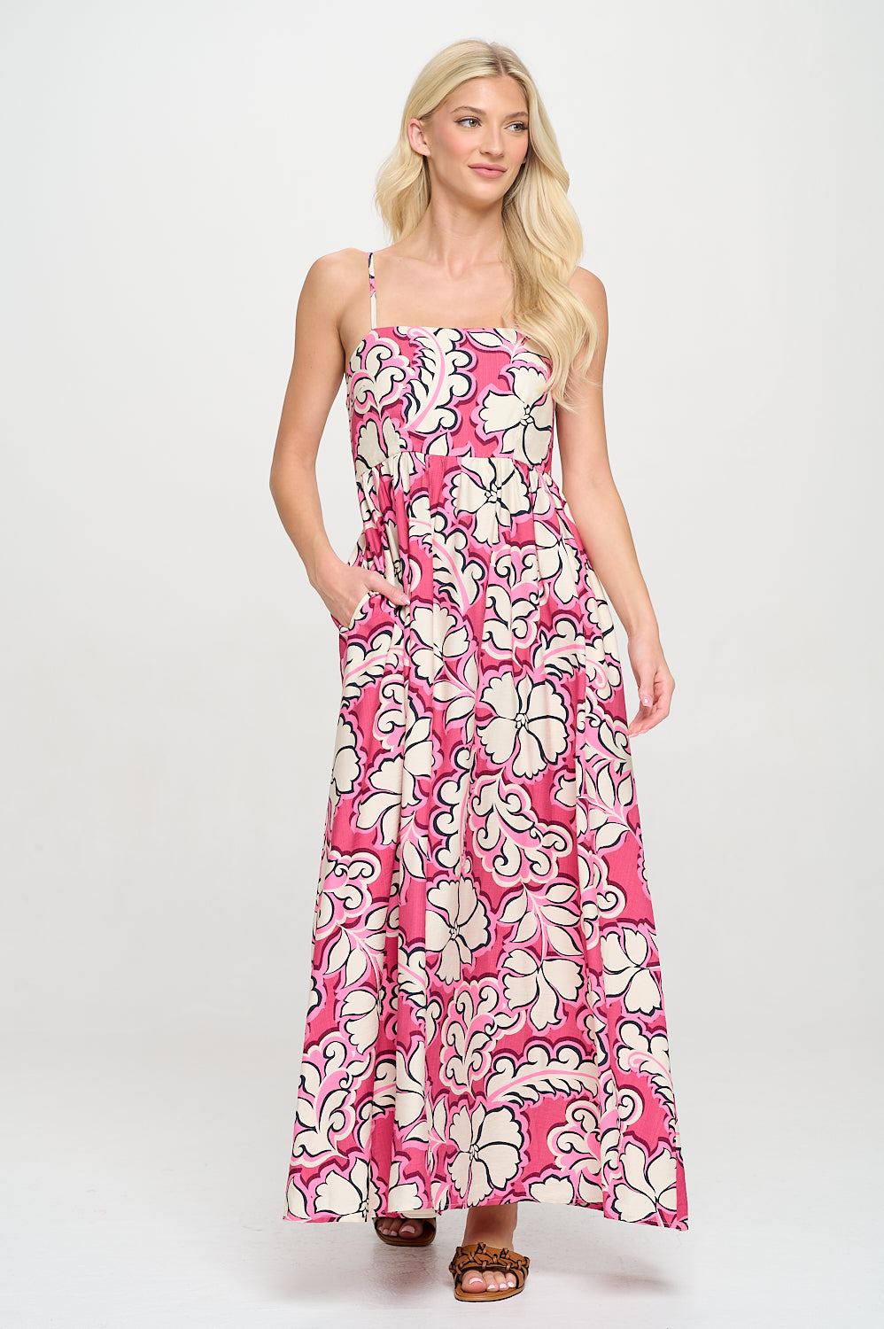 Model wearing the Rosy Bloom Maxi Dress with a vibrant pink and cream floral pattern and adjustable straps.