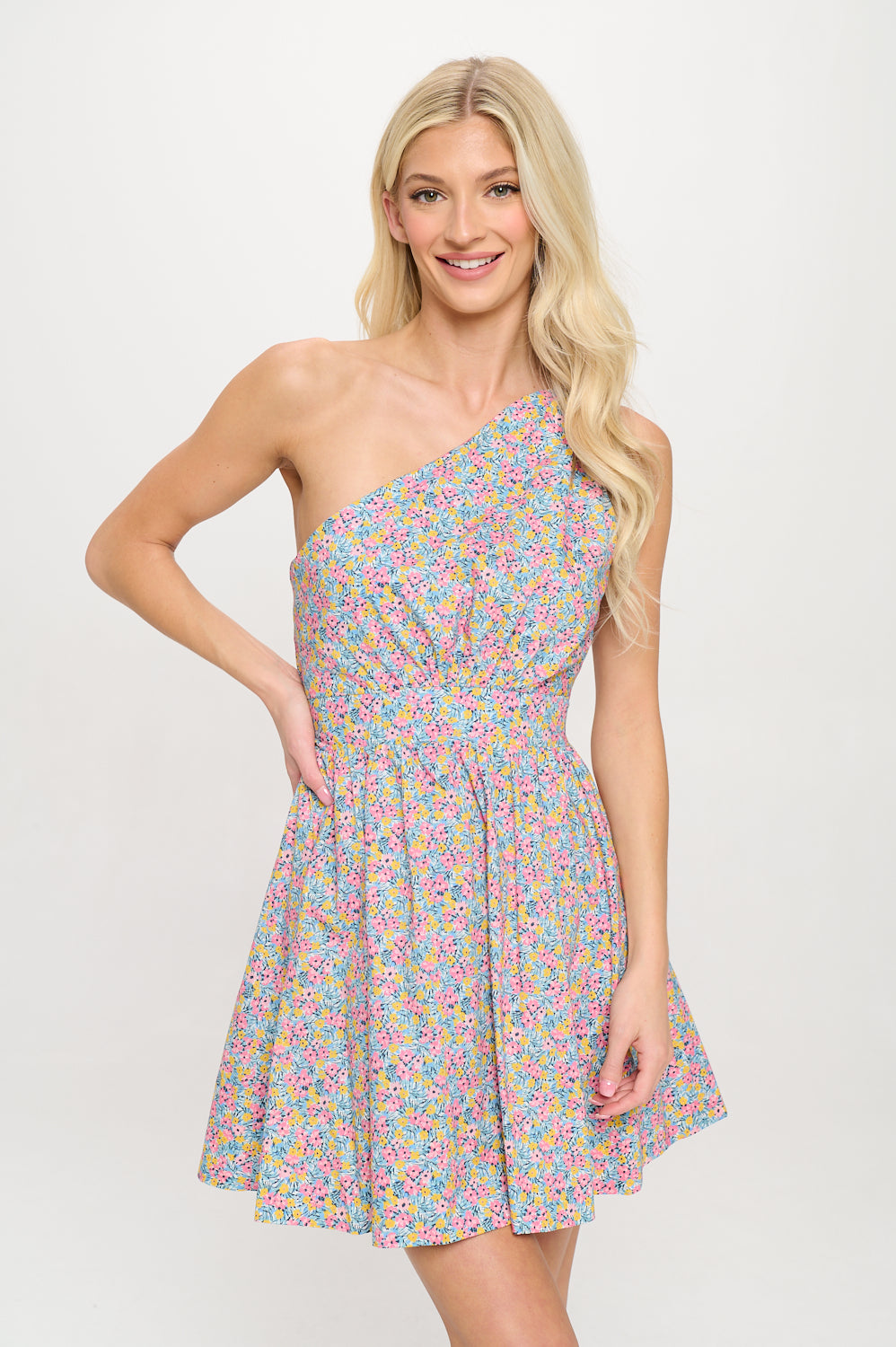 Model wearing a colorful floral one shoulder mini dress with a flared skirt, ideal for spring vacations or brunch occasions.