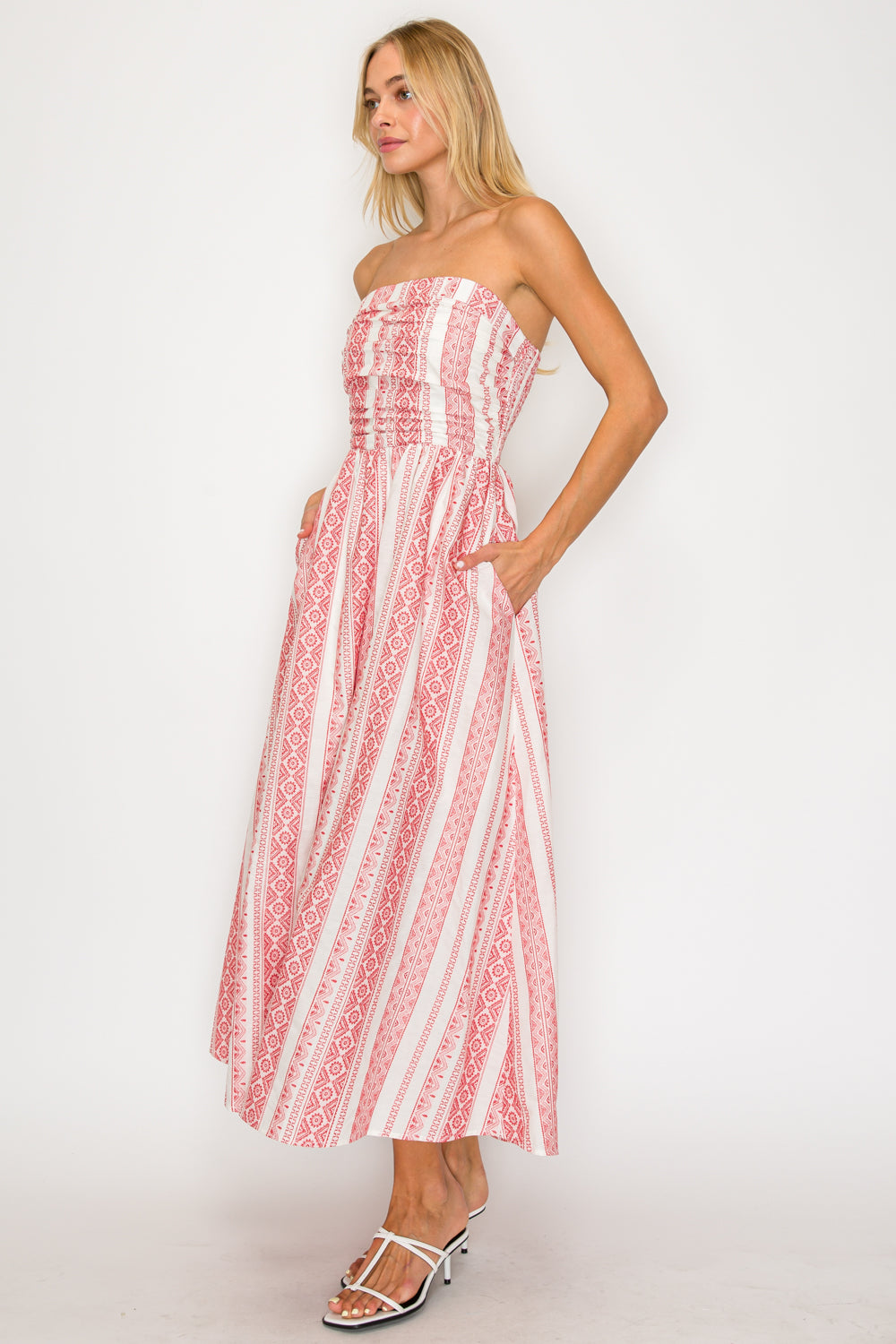 Woman wearing a strapless dress with red and white pattern on a white background