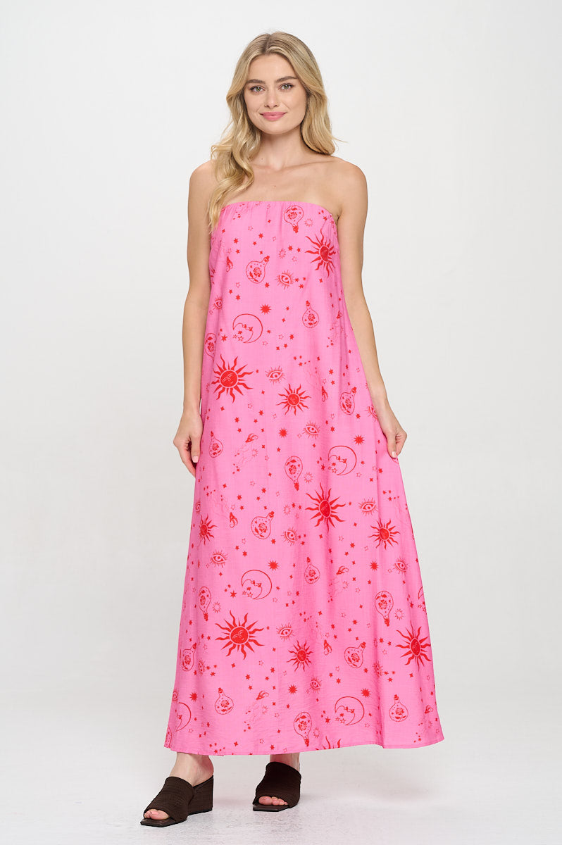 Model wearing a pink strapless tube maxi dress with red celestial print including stars, suns, and moons.