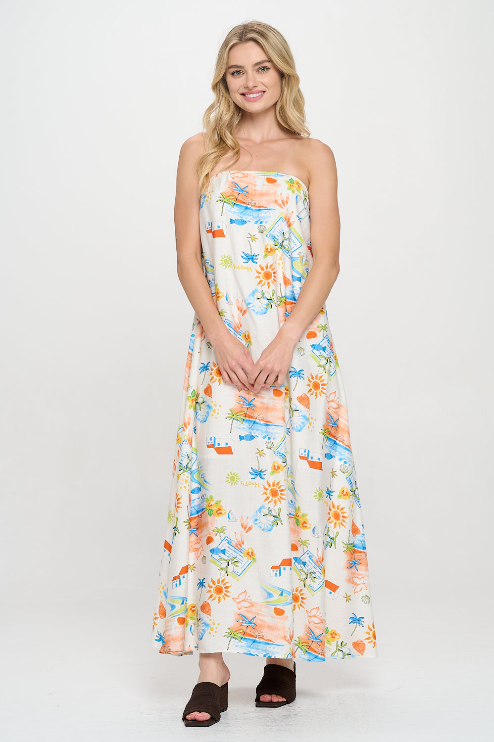 Model wearing a strapless printed maxi dress with coastal postcard motifs and an easy-flowing silhouette. Ideal for resort or vacation wear.