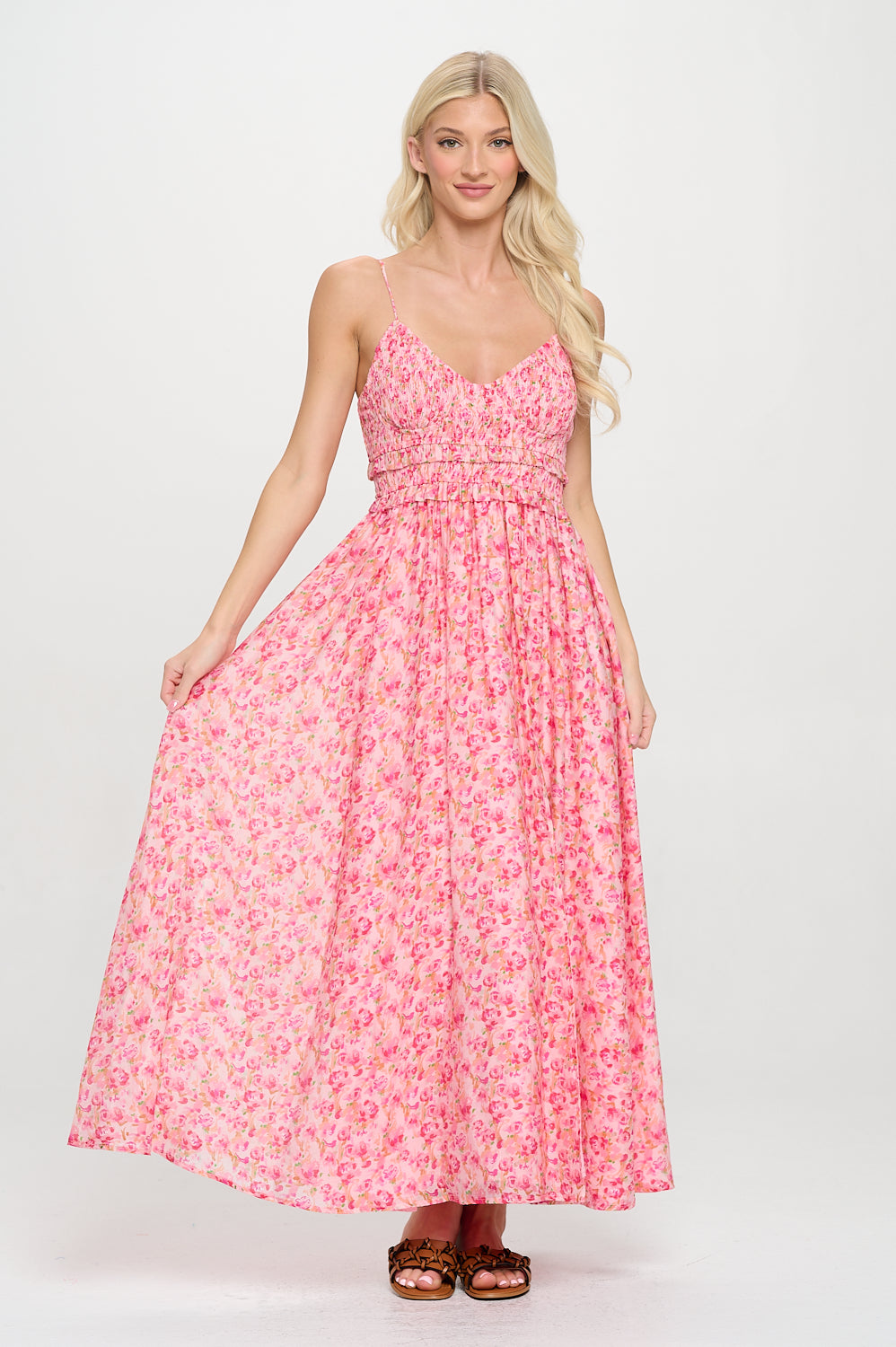 Model wearing a floral pink smocked maxi dress with spaghetti straps and a flowy A-line silhouette.