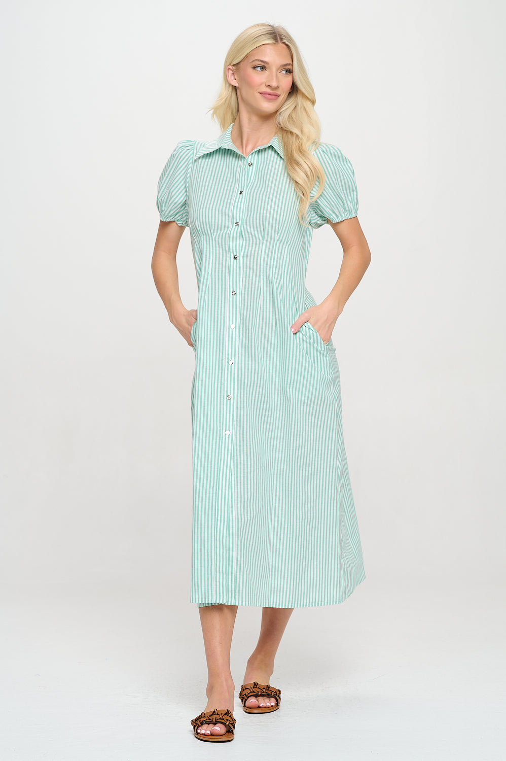 Model wearing a green striped puff sleeve shirt dress with buttons and side pockets.