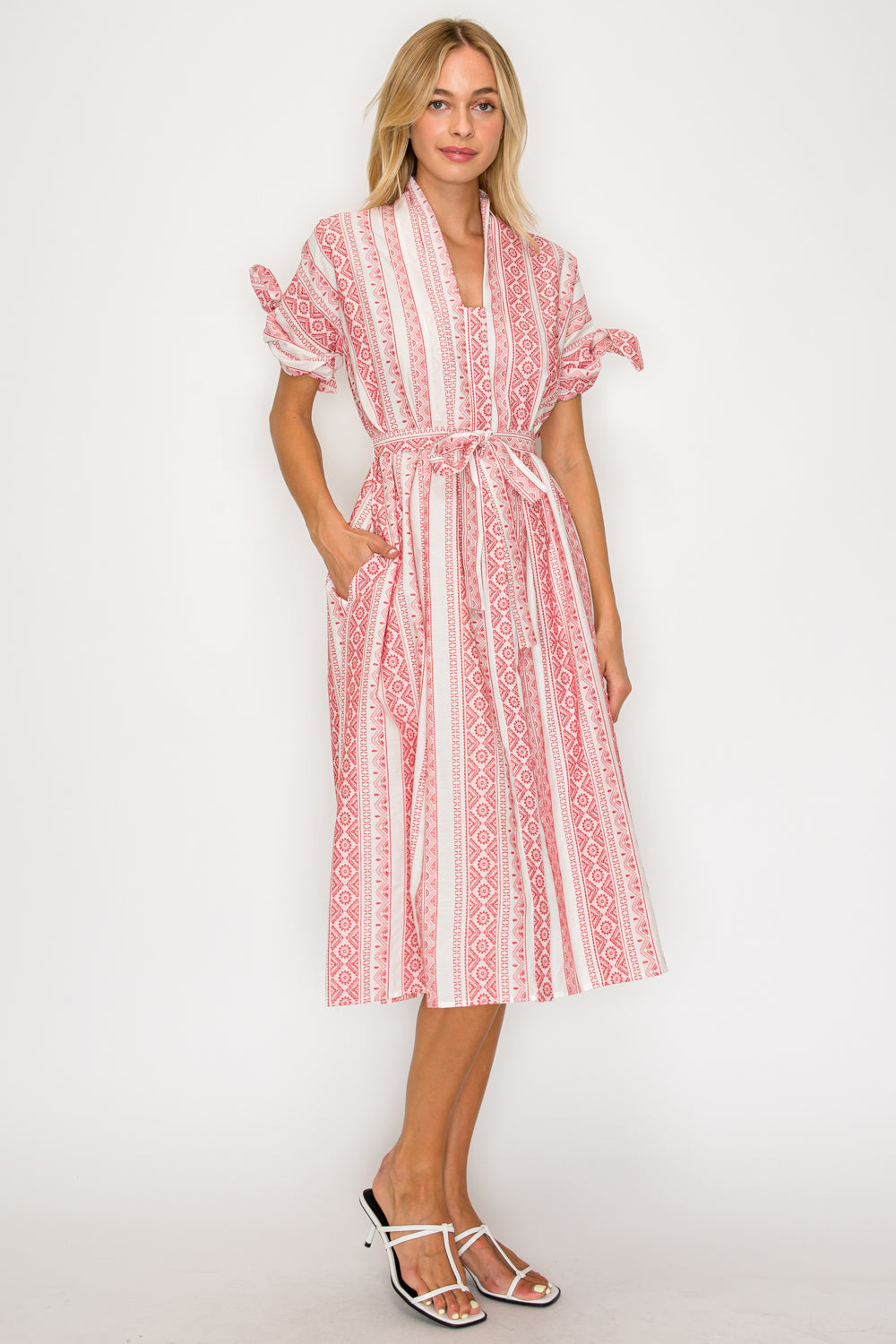 Woman wearing a red and white patterned dress on a white background
