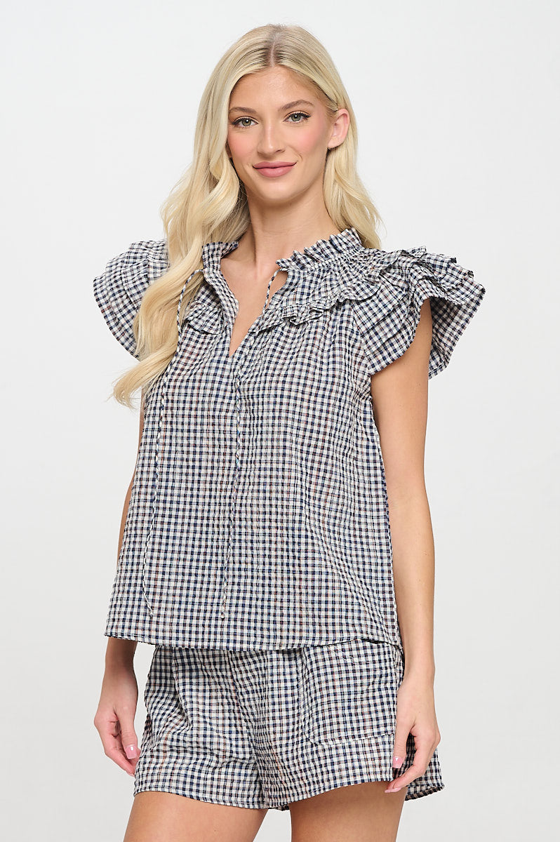 Model wearing high-waisted plaid shorts with an elastic waistband and front patch pockets.