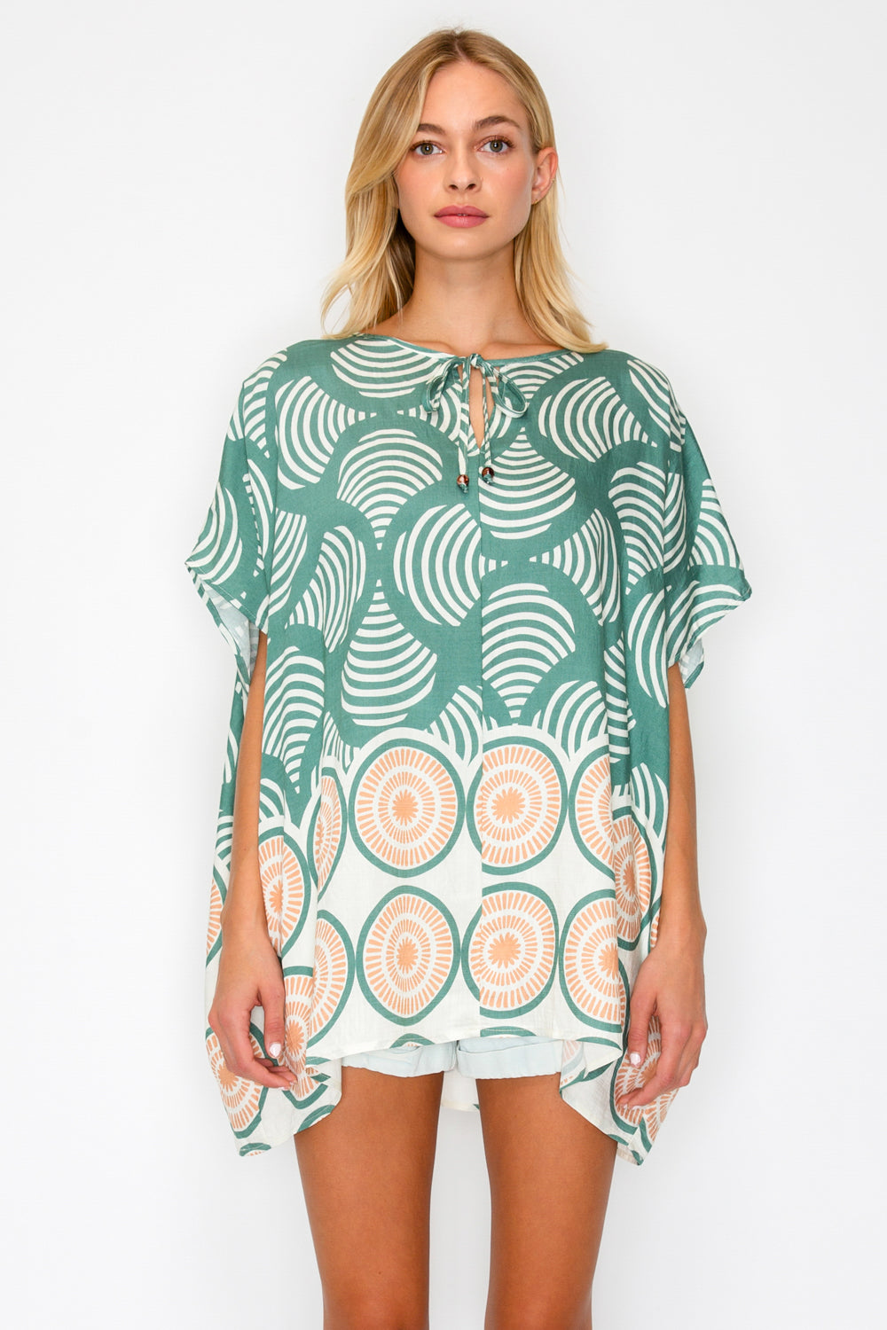 Woman wearing a green patterned dress on a white background