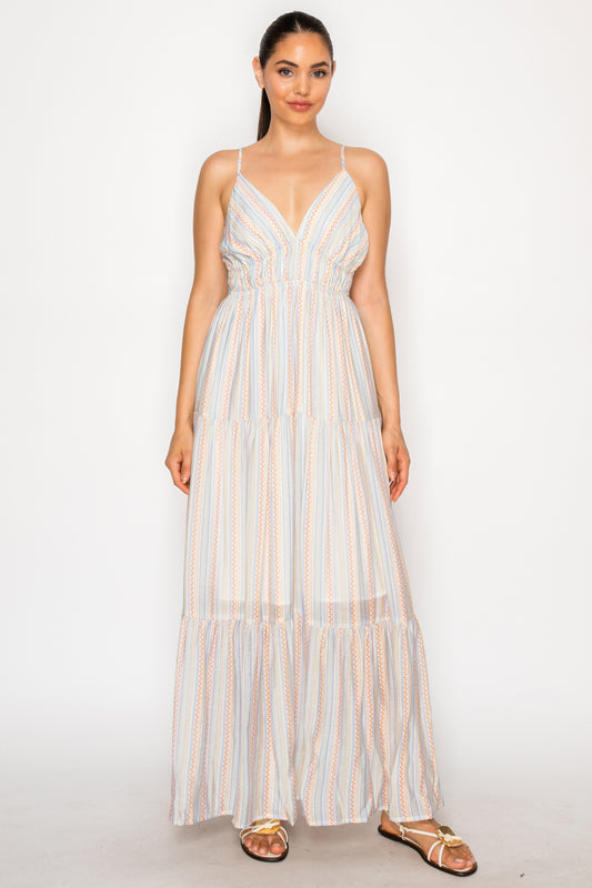 Model wearing the Harvest Lines Maxi Dress, a multicolor striped maxi dress with a V-neck, smocked waist, and tiered skirt.