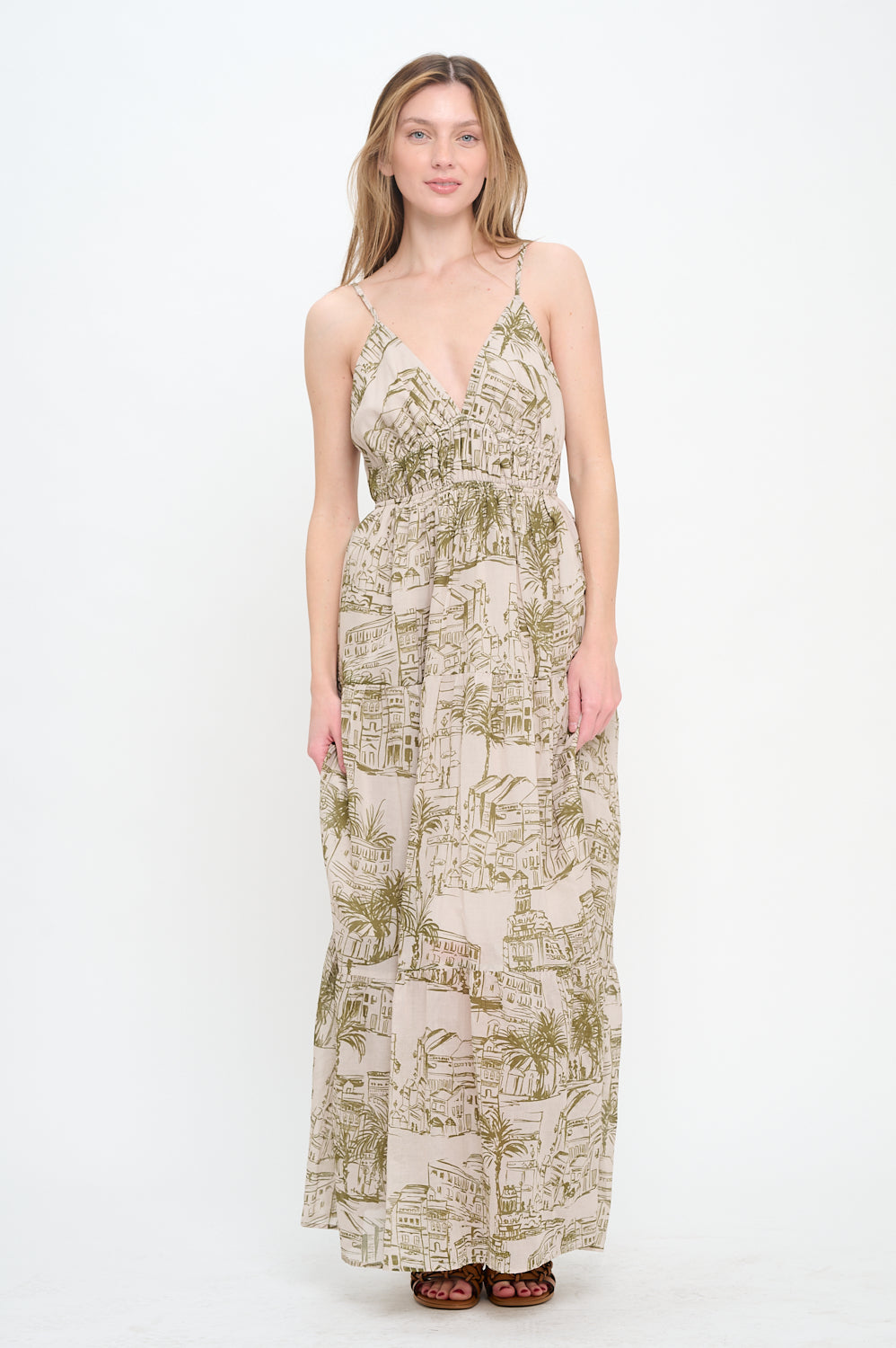 Model wearing Santorini Olive Sketch Maxi Dress with deep V-neckline, adjustable spaghetti straps, and olive village sketch print.