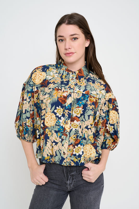 Model wearing floral print button-up blouse with puff sleeves and collared neckline