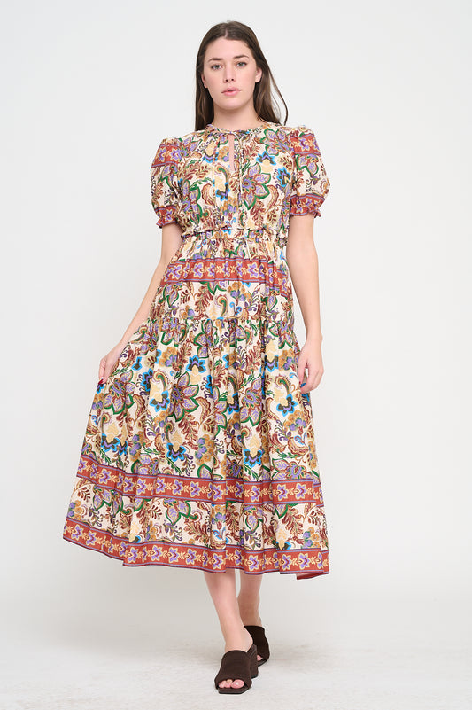 Model wearing ornate maxi dress with keyhole neckline and puff sleeves