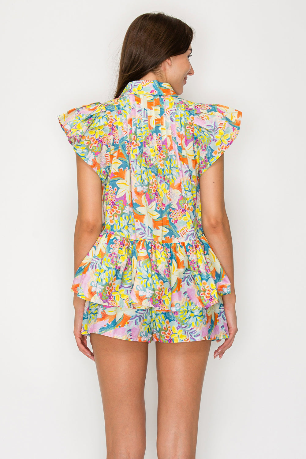 Woman wearing a colorful floral dress on a white background