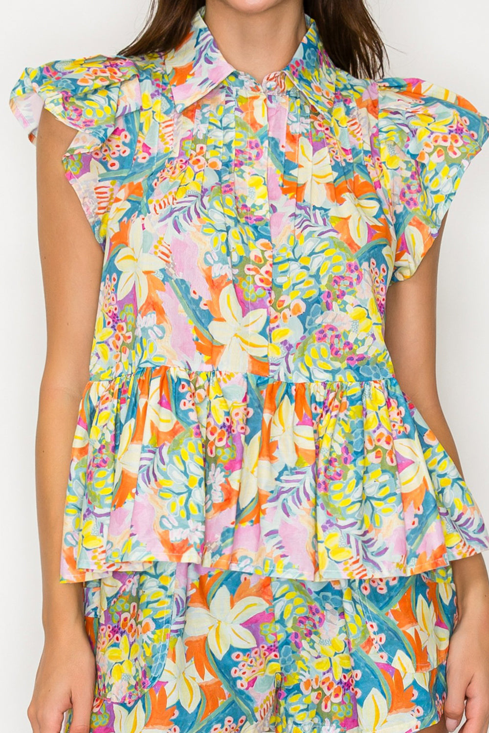 Multicolored floral dress with ruffled sleeves on a plain background