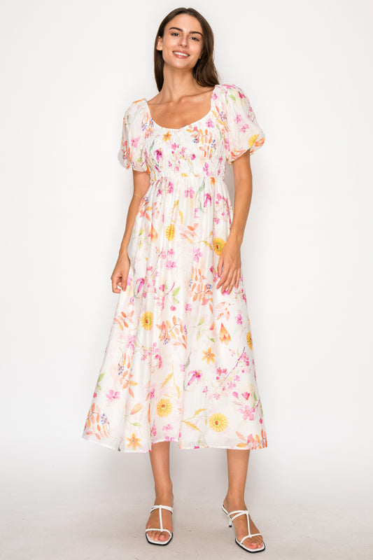 Model wearing the Sirena Garden Mini Dress, a white baby-doll style mini dress with a colorful dainty floral print and thin adjustable straps.