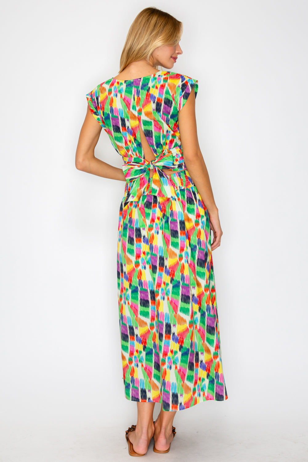 Woman wearing a colorful patterned dress on a white background