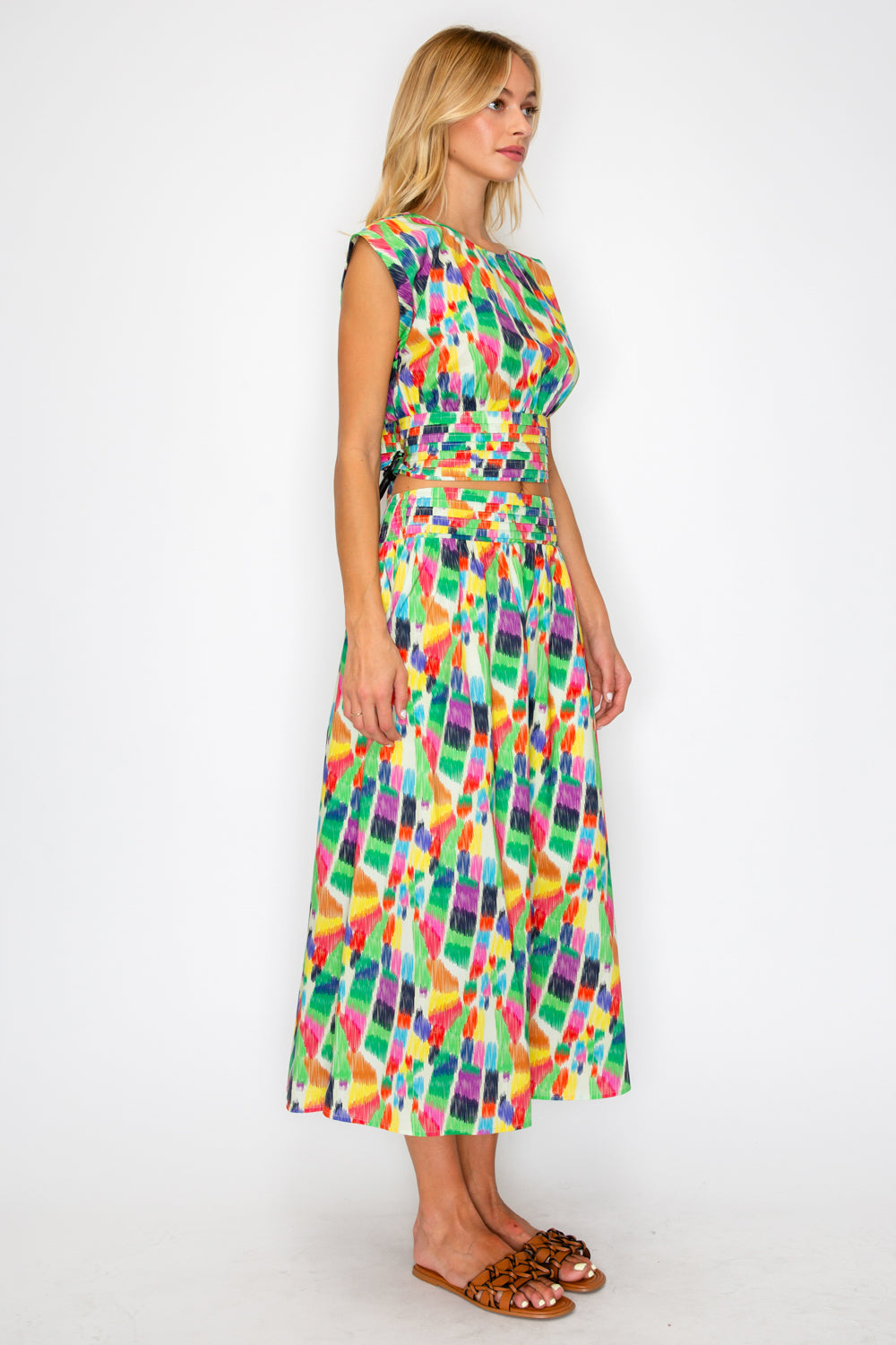 Woman wearing a colorful patterned dress on a white background