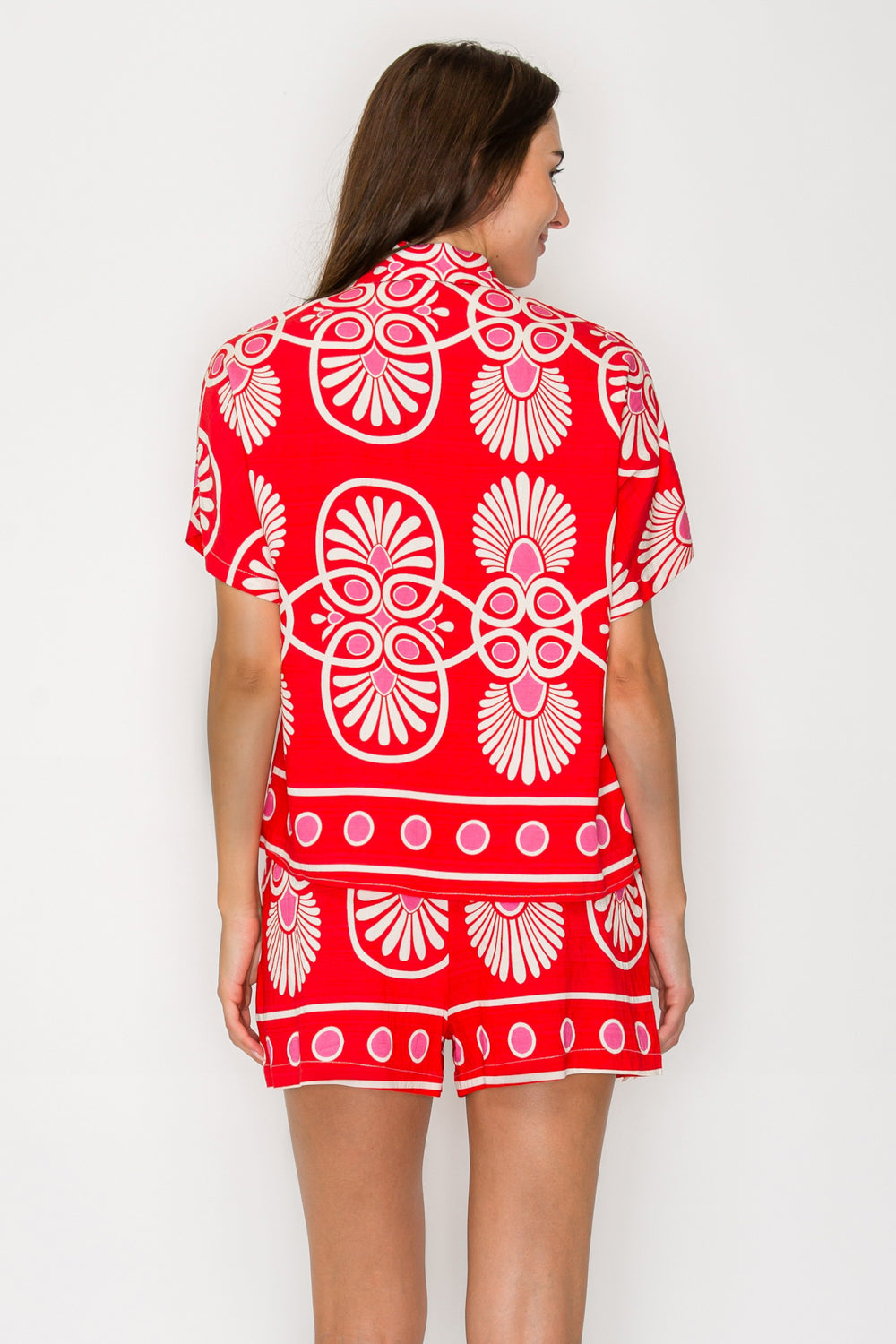Woman wearing a red and white patterned outfit on a plain background