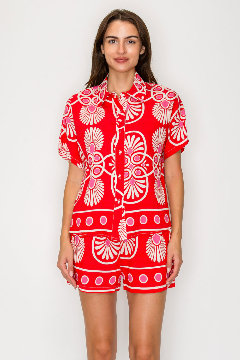 Woman wearing a red and white patterned outfit on a plain background