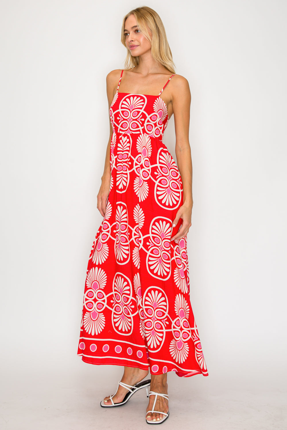 Woman wearing a red dress with white floral patterns on a white background