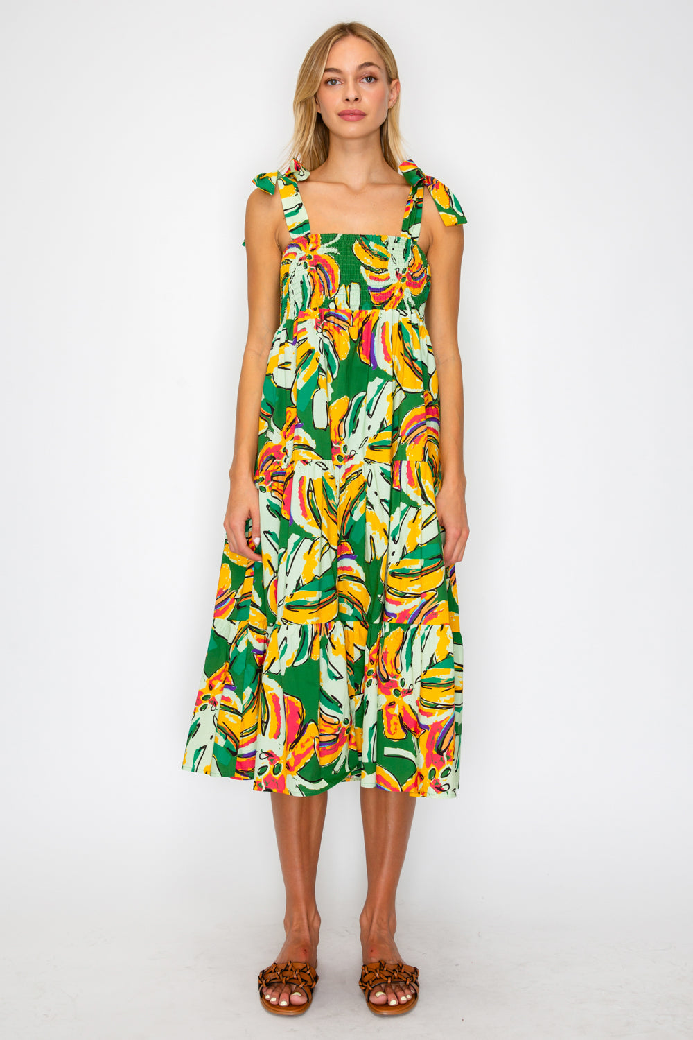 Woman wearing a colorful dress with a banana leaf pattern on a white background