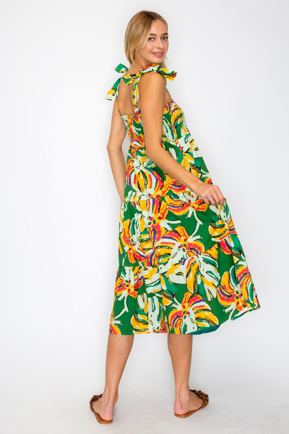 Woman wearing a colorful dress with a green background