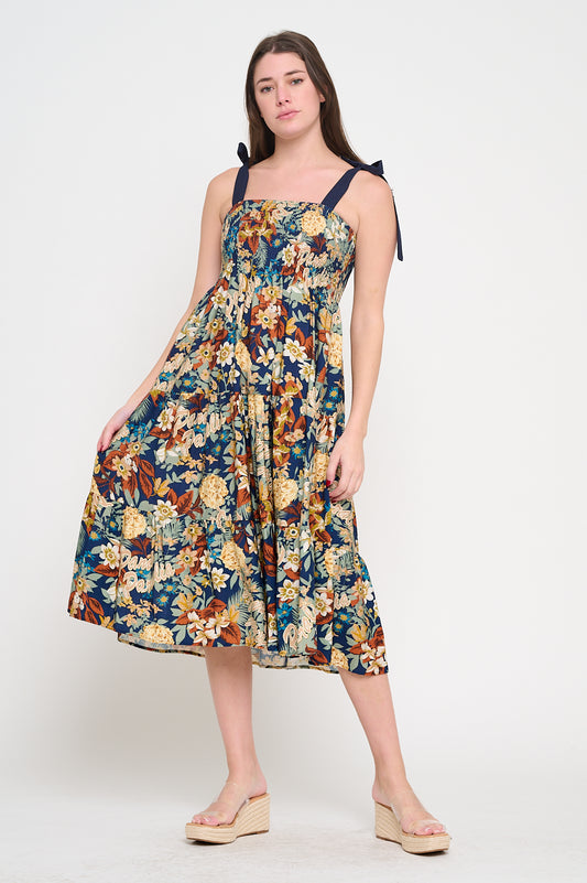 Model wearing floral smocked midi dress with tie shoulder straps and tiered skirt