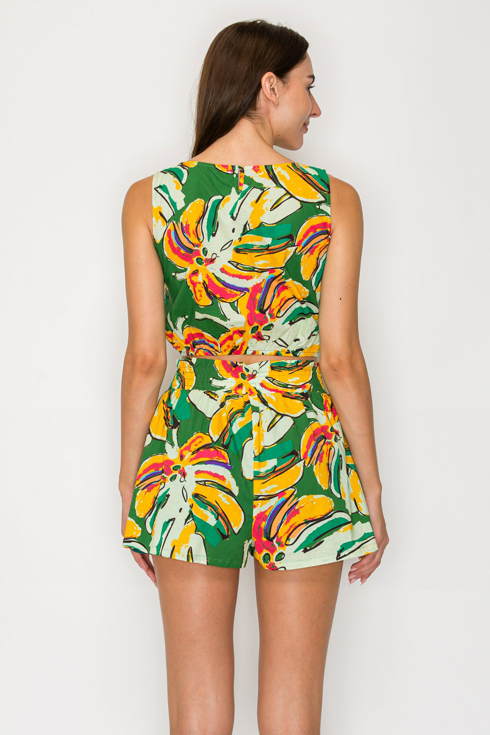 Woman wearing a colorful floral romper on a white background