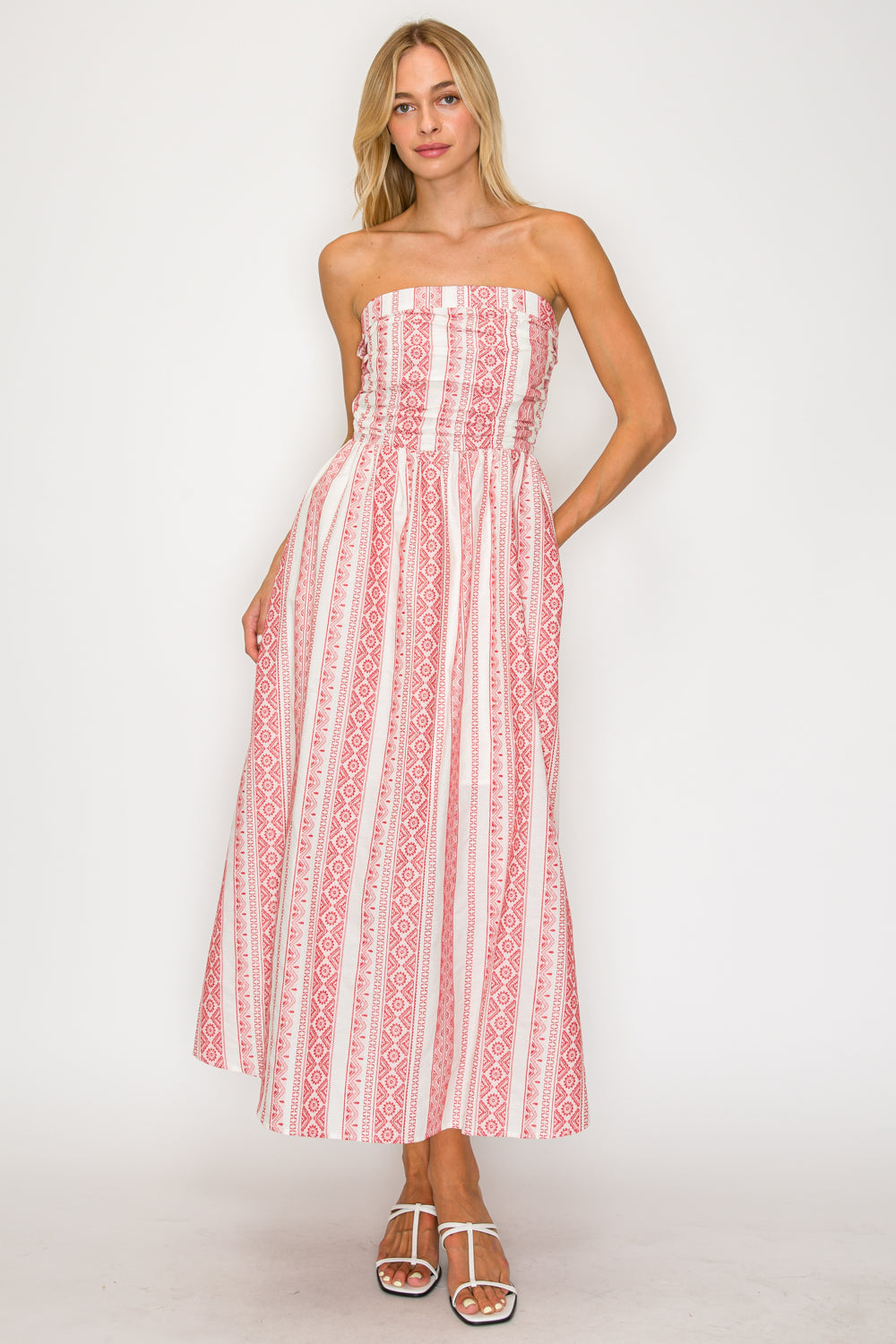 Woman wearing a strapless dress with red and white pattern on a white background