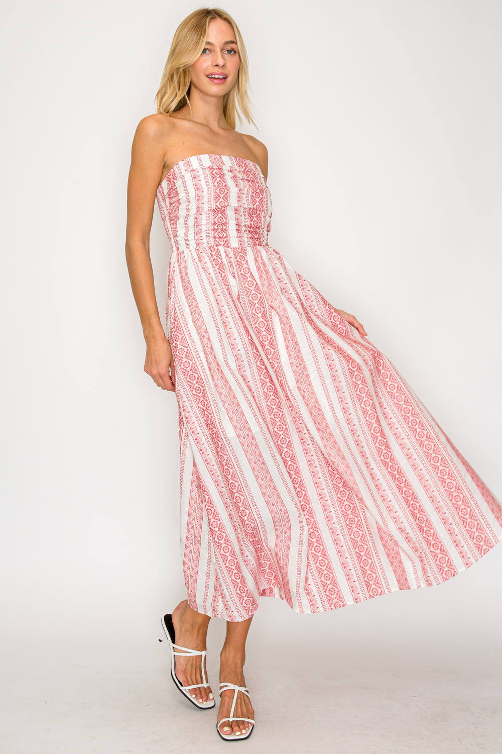 Woman wearing a strapless red and white striped dress on a white background
