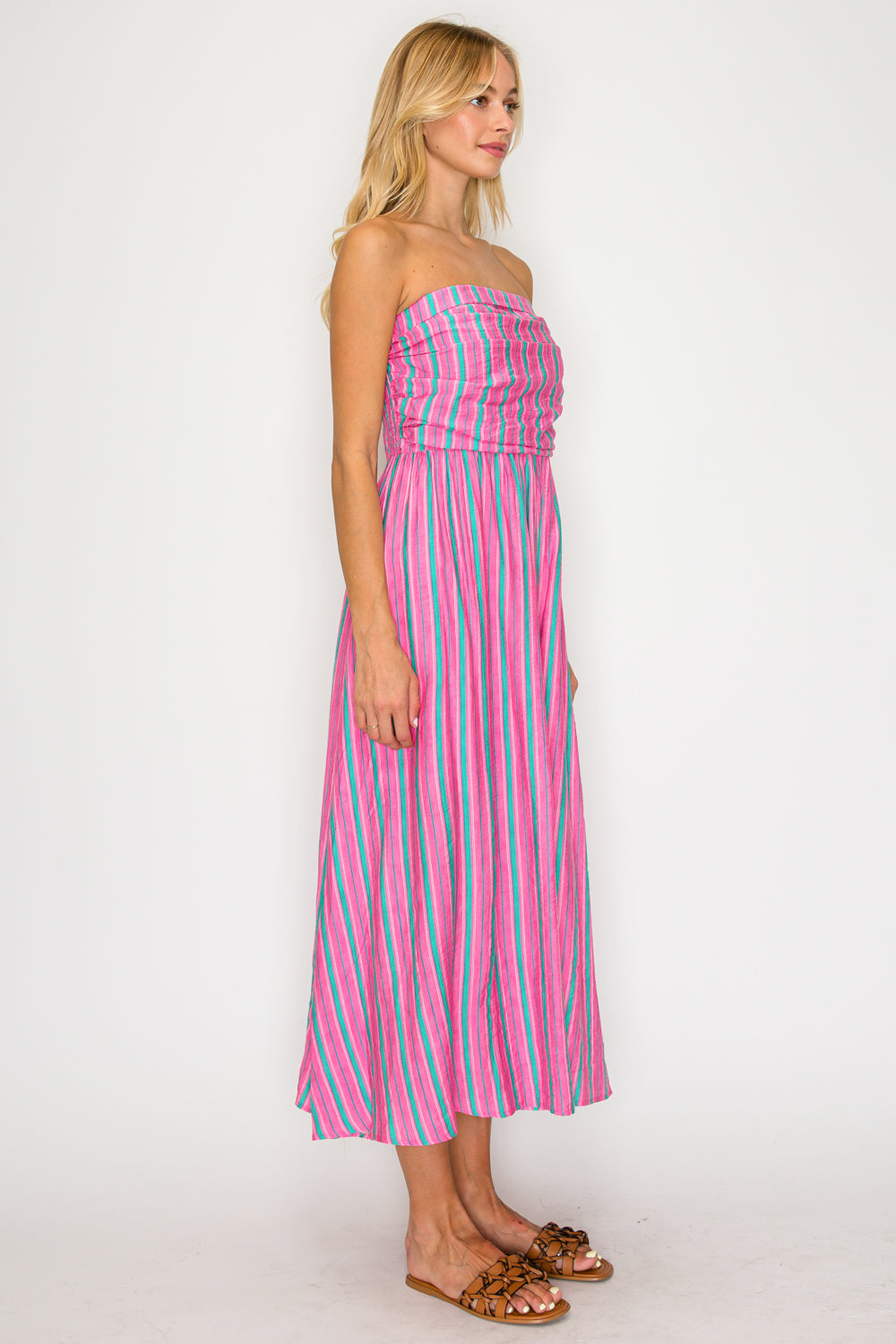 Woman wearing a pink and blue striped dress on a white background