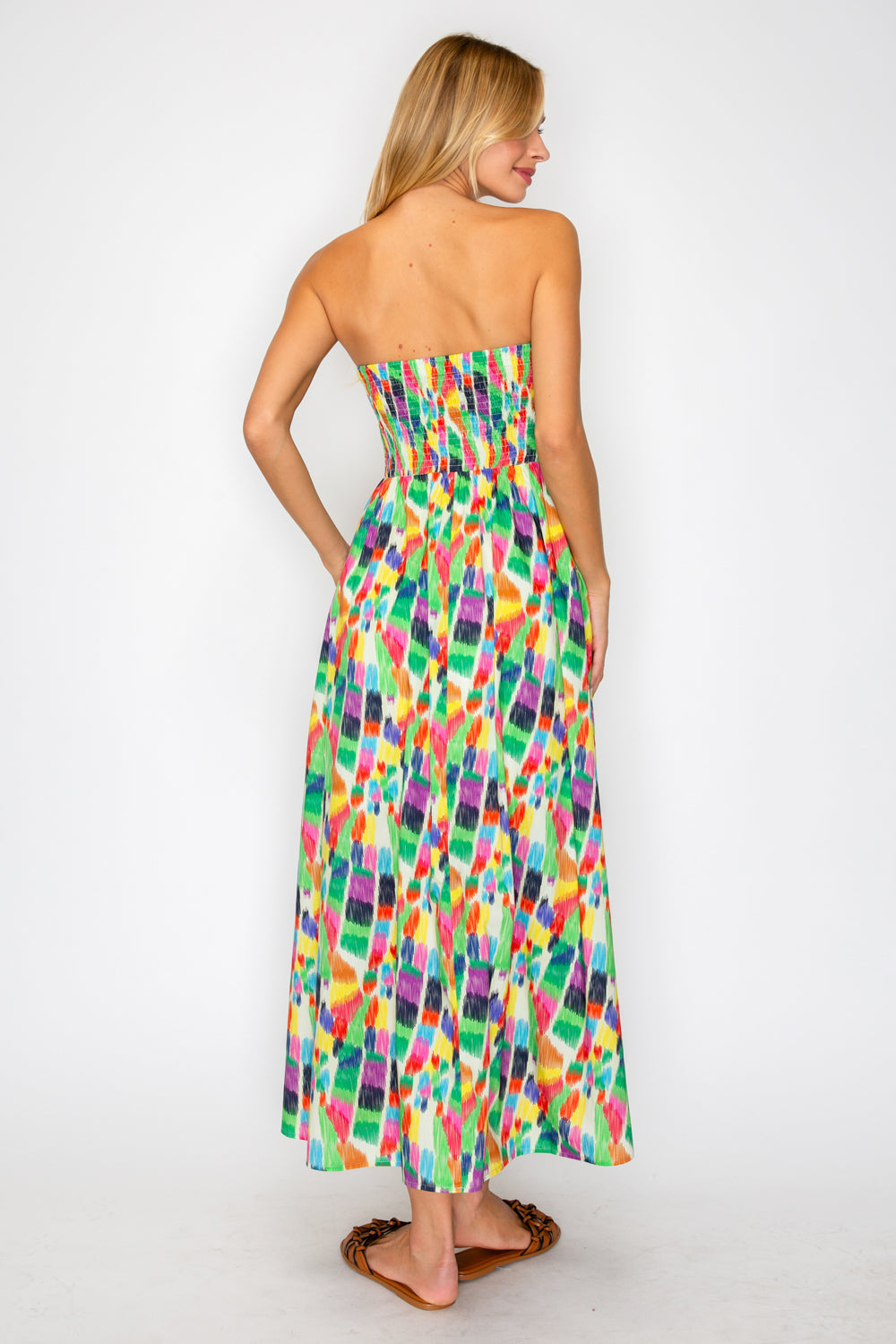 Woman wearing a colorful strapless dress on a white background