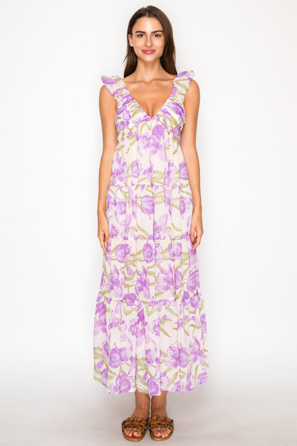 Model wearing the Aphrodites Garden Maxi Dress, a purple floral print dress with a V-neck, ruffle sleeves, and a tiered maxi skirt.