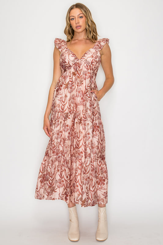 Model wearing a sleeveless floral maxi dress with ruffle straps and tiered skirt.