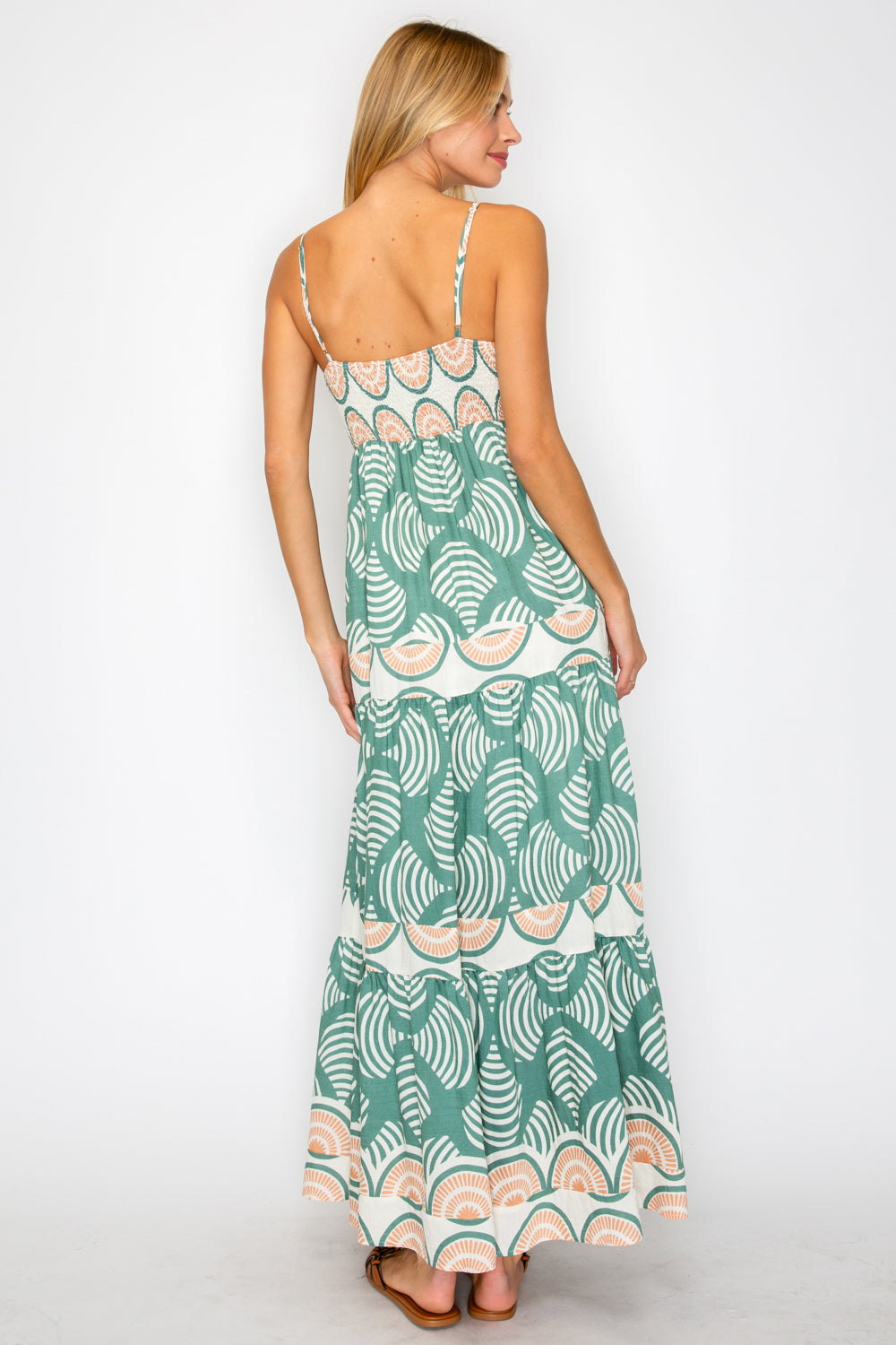 Woman wearing a green patterned dress on a white background