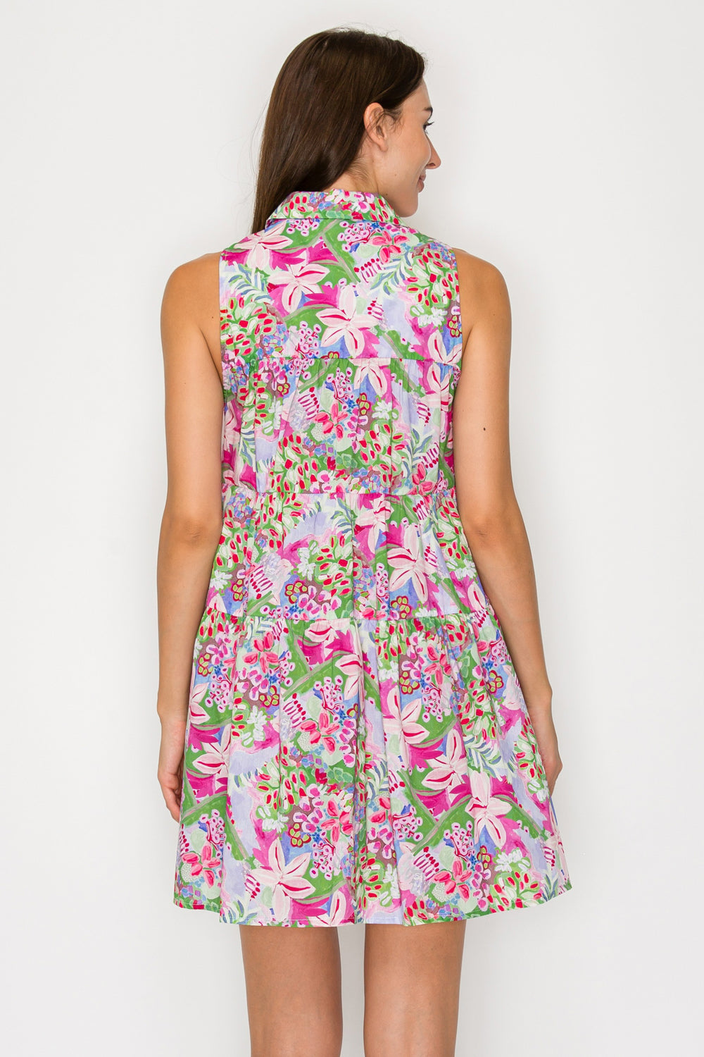 Woman wearing a colorful floral dress against a white background