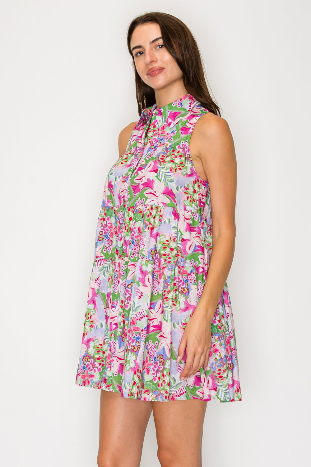 Woman wearing a colorful floral dress against a white background