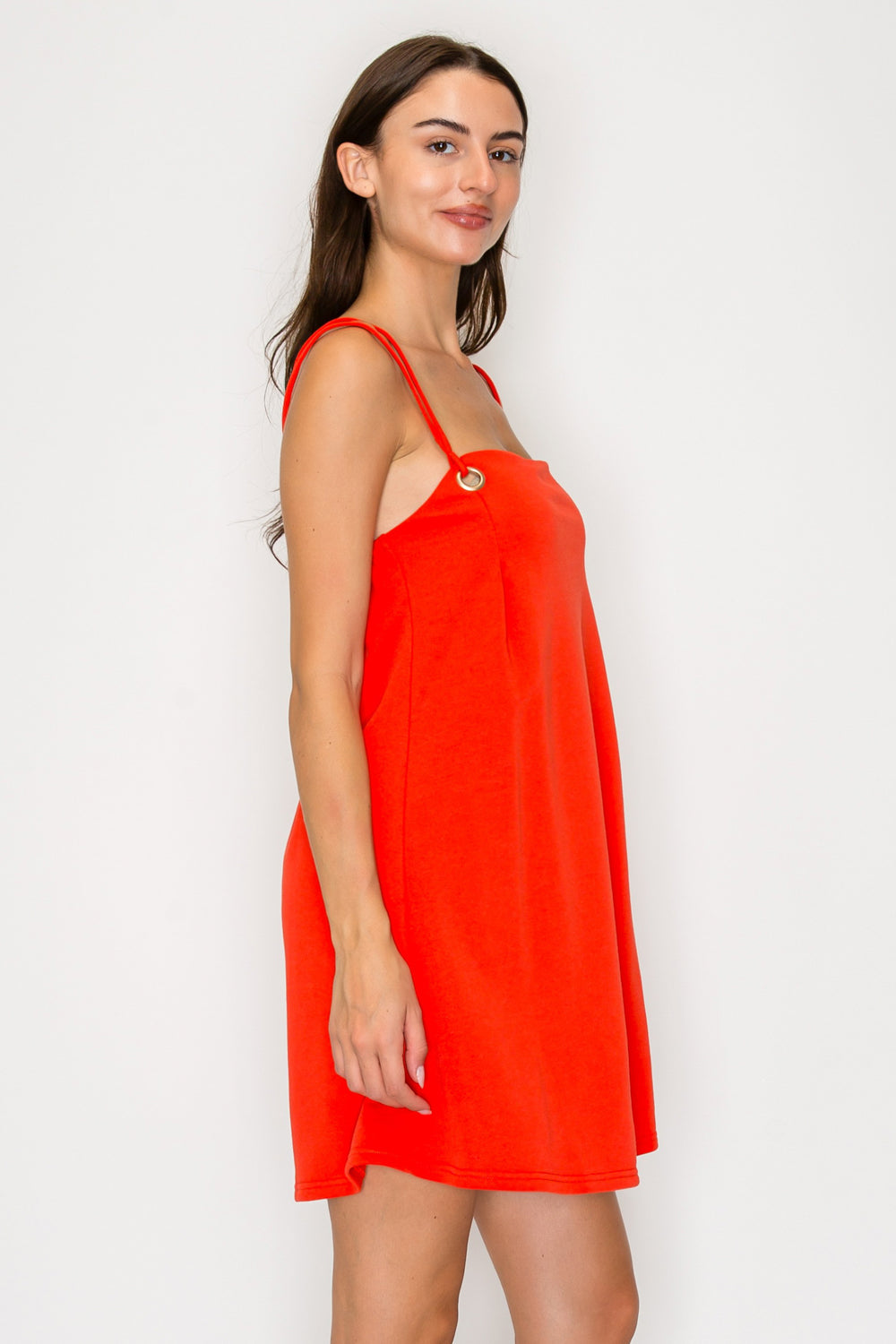 Woman wearing a bright orange dress against a white background