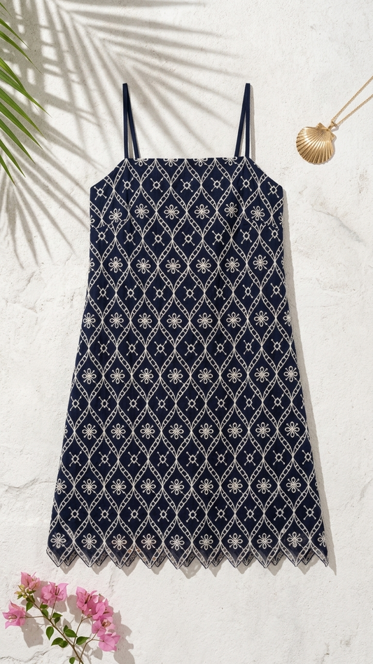 Flat lay of Selene's Embroidery Mini Dress, a navy blue cotton poplin shift dress featuring a cream diamond lattice print and a zig-zag scalloped hem.