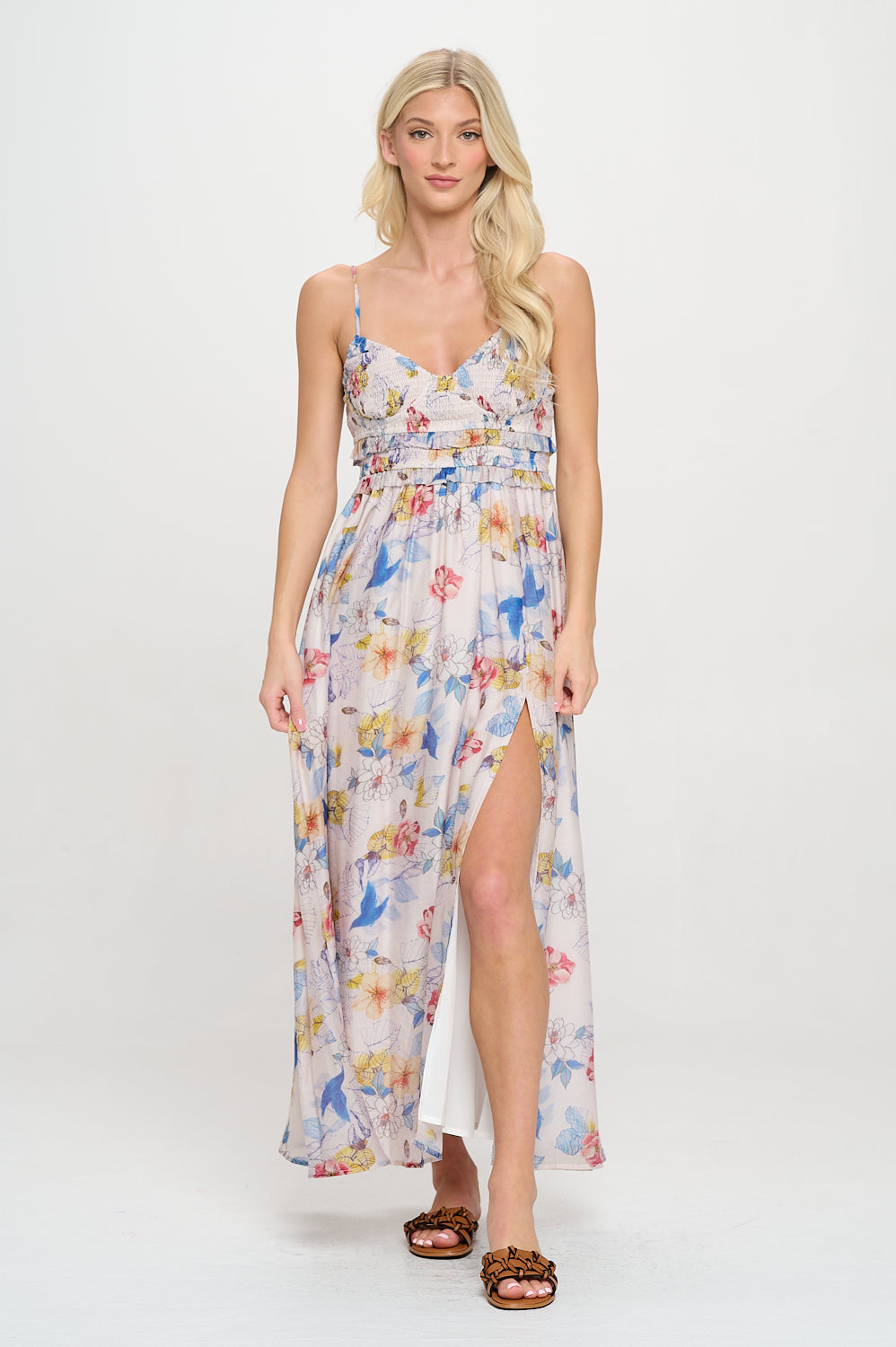 Model wearing a floral sweetheart maxi dress with spaghetti straps, smocked bodice, and side slit.