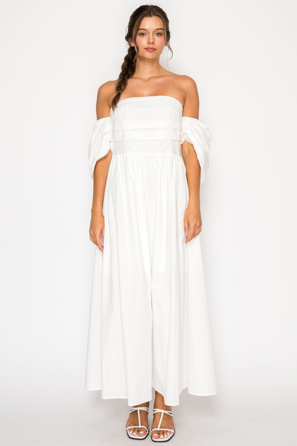 Model wearing the White Poplin Tube Maxi Dress, a strapless white dress with detached puff sleeves and a full maxi skirt.