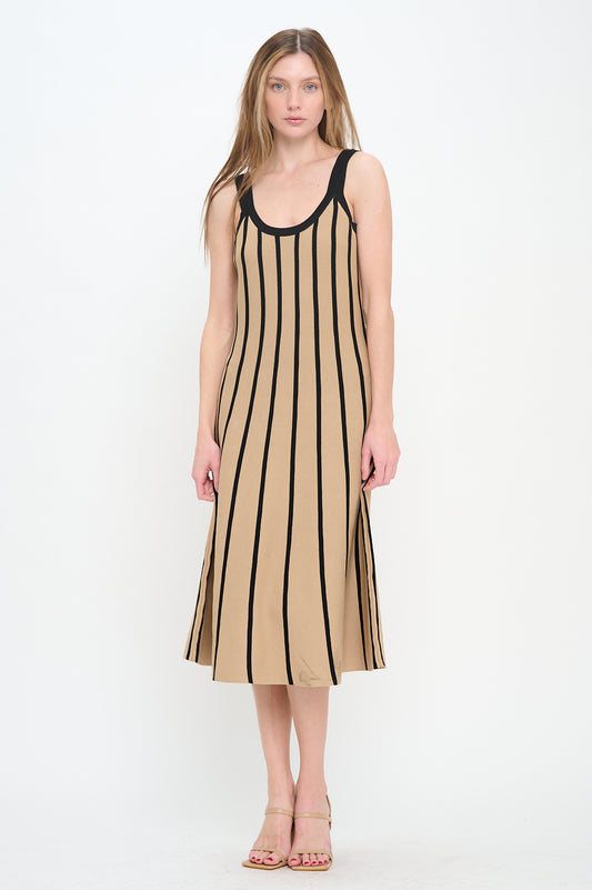 Woman wearing a sleeveless ribbed knit midi dress with vertical black stripes on a tan background, round neckline, and flared hem.