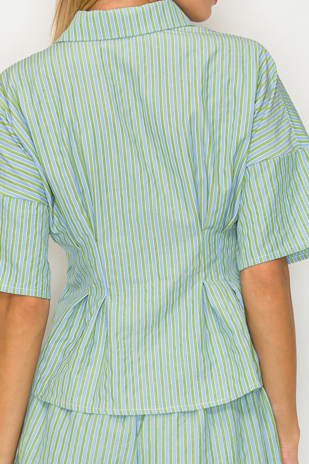 Person wearing a green and white striped outfit with a plain background