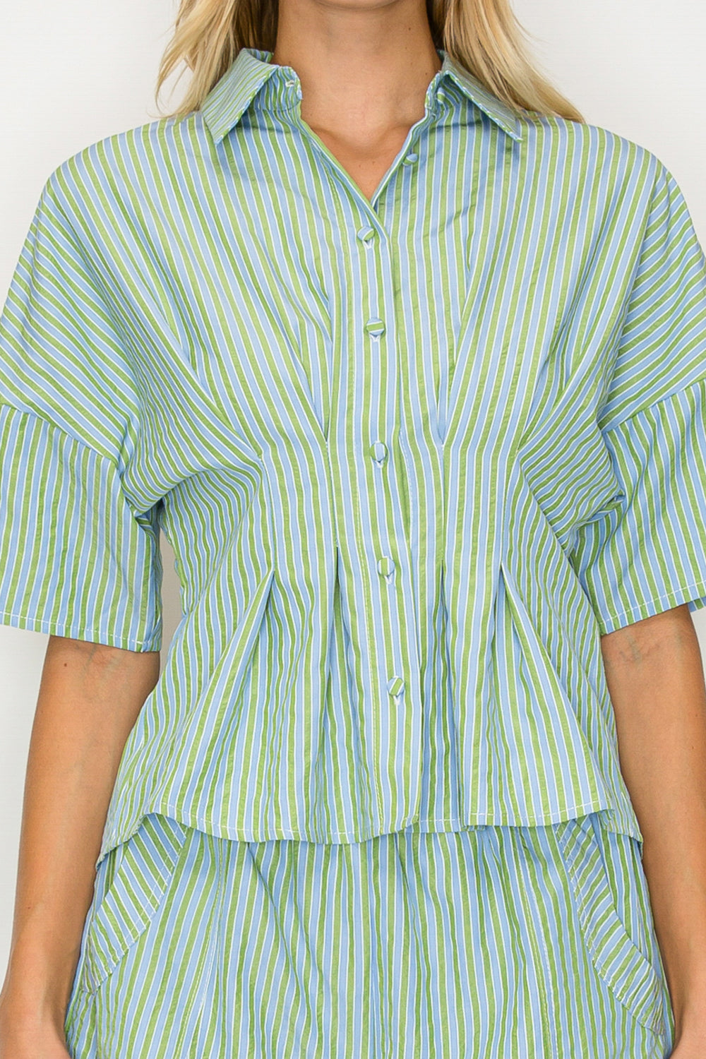 Person wearing a green and white striped shirt and pants against a white background