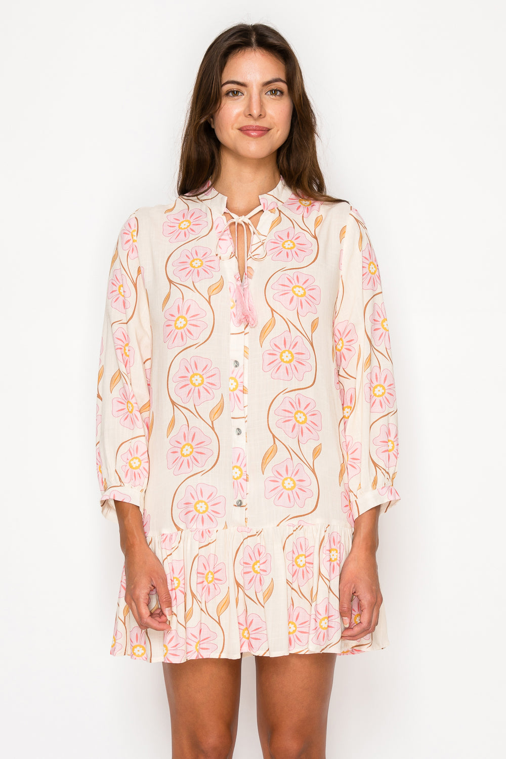 Model wearing the Peony Glow Maxi Dress, a pink floral print dress with a smocked bodice, puff sleeves, and a long A-line skirt