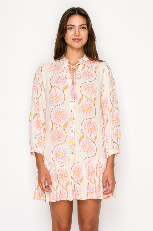 Model wearing the Peony Glow Maxi Dress, a pink floral print dress with a smocked bodice, puff sleeves, and a long A-line skirt